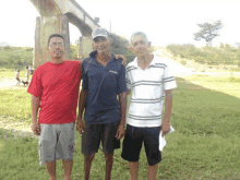 three men are posing for a picture with one wearing a shirt that says ' aruba ' on it