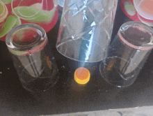 three empty glasses sit on a table next to a yellow cap