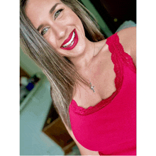 a woman wearing a red tank top and a cross necklace