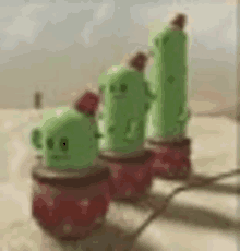 a row of green cactus figurines sitting on top of each other on a table .