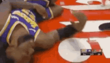 a basketball player is laying on the floor with his head on the table .