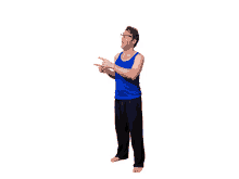 a man in a blue tank top and black pants is pointing upwards