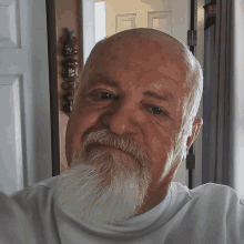 a man with a beard and a white shirt is smiling for the camera