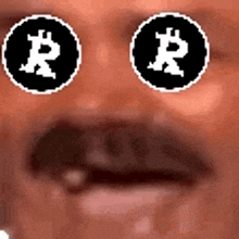 a close up of a person 's face with two circles with a bitcoin symbol on them .