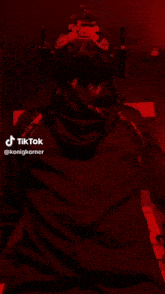 a man wearing a helmet and a scarf is standing in a dark room with tiktok written on the bottom right corner