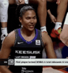 a basketball player wearing a keesusk jersey is sitting on the court