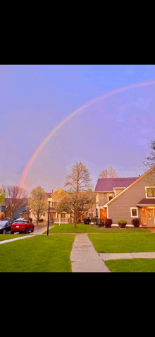 a double rainbow is visible over a residential area