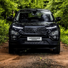 a black harrier is driving down a dirt road