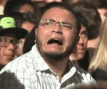 a man wearing glasses is crying in a crowd .