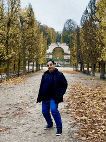 a man stands in a park with trees and benches