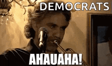 a man is playing a trumpet in front of a microphone with the words `` democrats ahauaha ! ''