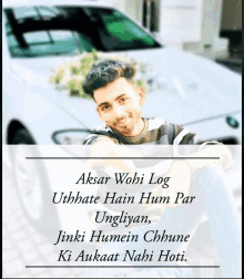 a young man sitting in front of a white car with a quote in a foreign language