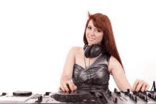 a woman wearing headphones is playing music on a dj mixer .