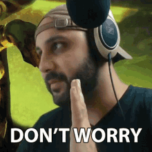 a man with a beard wearing headphones and a hat says " don 't worry "