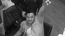 a black and white photo of a man sitting in a chair .