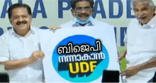 three men are holding a sign that says udf in a foreign language .