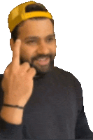 a man with a beard wearing a yellow hat giving the middle finger