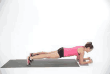 a woman is doing plank exercises on a yoga mat .