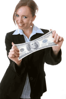 a woman holds a 100 dollar bill in her hand