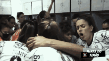 a group of female athletes are huddled together in a locker room with minas do timão written on the bottom