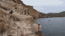 a group of people are standing on a rocky cliff overlooking a body of water with the word africa written on the rock