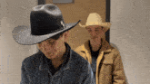 two young men wearing cowboy hats and jackets are standing next to each other