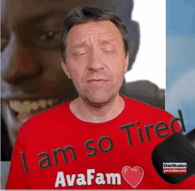 a man wearing a red t-shirt that says i am so tired