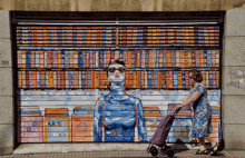 a woman pushes a shopping cart in front of a mural of a woman with the word art on the wall behind her