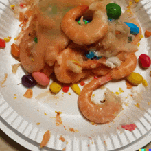 a paper plate topped with shrimp covered in candy