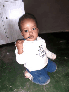 a baby wearing a white shirt that says " your smile makes me happy "