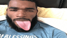 a man with a beard is sticking his tongue out while wearing a shirt that says blessings