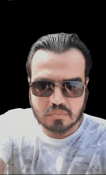 a man with a beard and sunglasses is wearing a white shirt