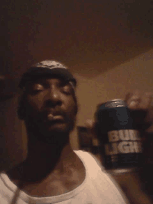 a man is holding a can of bud light in his hand