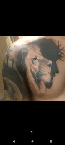 a man has a tattoo of a lion with a crown of thorns on his chest