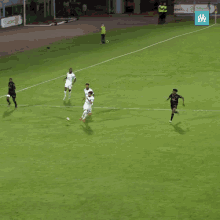 a soccer game is being played on a field with a sign that says ' olympique lyonnais ' on it