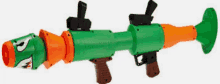 a green and orange toy rocket launcher with the letter p on the front