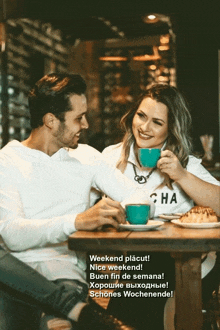 a man and a woman are sitting at a table with a cup of coffee in front of them