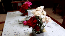 a vase of flowers sits on a table with a teapot