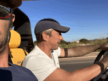 a man wearing a hat is driving a vehicle with the word pro on the seat