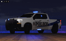 a white police truck is parked on a dock at night