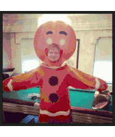 a person is dressed as a gingerbread man with a picture of a man on his face .