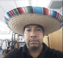 a man wearing a sombrero is taking a selfie in a store