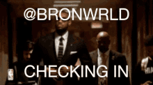 a man in a suit and tie is walking down a hallway with the words bronwrld checking in above him