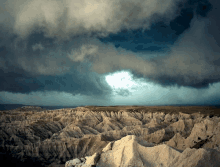 the sun is shining through the clouds over a desert