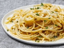 a close up of a plate of spaghetti with cheese on a table .