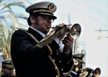 a man in a military uniform plays a trumpet in a band