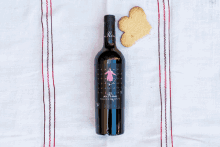 a bottle of wine with a heart shaped cookie on a table