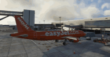 a red easyjet airplane is parked on the tarmac