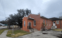 a brick building with a stained glass window and stairs leading up to it