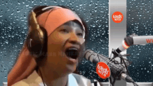 a woman wearing headphones singing into a microphone that says wish 107.5 on it